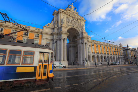 LISBON - PORTUGAL, November 5, 2018: An old traditional tram passing by Triumphal Arch on Commerce Square in Lisbon, Portugal.のeditorial素材