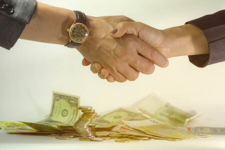 Coins Stacks with Business people shaking hands, successful deal conceptの写真素材