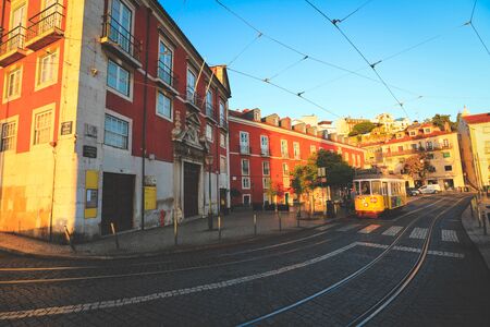 Lisbon - Portugal, November 5, 2018: Old building with vintage yellow retro tram on narrow street tramline  in the old district of the city, Lisbon, Portugalのeditorial素材