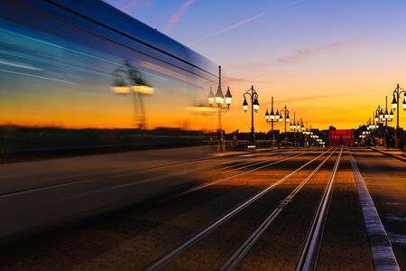 Light trails of tramway on Pont de Pierre stone bridge over garonne river in Bordeauxの写真素材