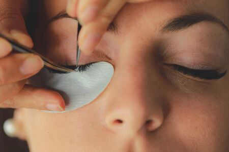 Eyelash extension procedure. Woman eye with long eyelashes. Macro, selective focusのeditorial素材