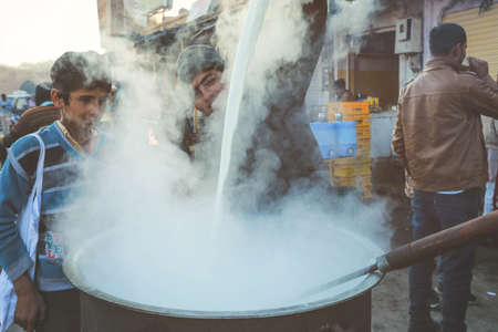 Smiling India man pouring mike in front of tea shop in Rajasthanのeditorial素材