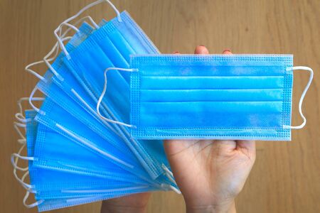 Medical mask, medical protective masks on hand with wooden backgrondの写真素材