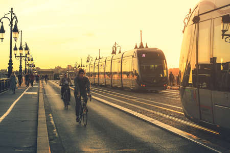 BORDEAUX, FRANCE - 26 October, 2019 : Modern city tram on Pont de Pierre bridge with St Michel churh in Bordeaux at sunsetのeditorial素材