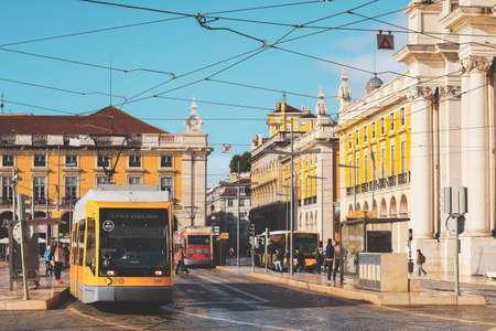 modern yellow tram and Rua Augusta Street Triumphal Arch in Praca do Comercioのeditorial素材