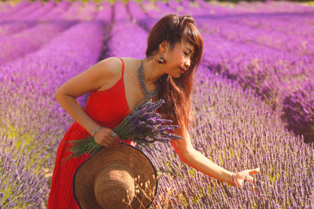 Beautiful asian woman in red dress on the lavender field.の写真素材