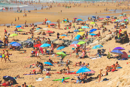 Crowded beach full of people resting on beach during their vacation in summerのeditorial素材