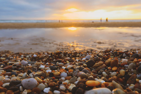 Sunlights on stone beach with view of sunsetの写真素材
