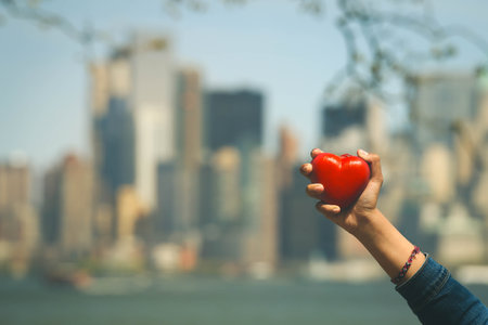 Love concept, heart shape love symbol in girl's hands on Manhattan skyline background in vintage styleの写真素材