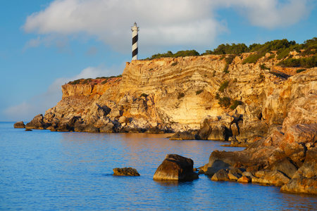 Lighthouse at sunset on top of the cliffs with blue oceanの写真素材