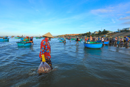 Mui ne - Vietnam - January 22, 2019: Vietnamese woman carry shelles at famous fishing village in Mui ne, Vietnamのeditorial素材