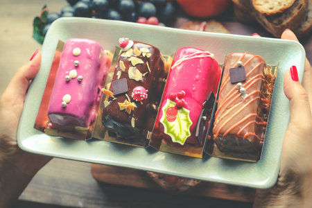 Selective focus on chocolete cake, different types of cakes on green plate, festive coceptの写真素材