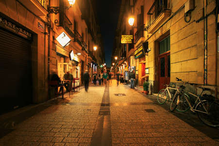 Spain - San-Sebastian - October 27-2017: San Sebastian typical small street view with lively tapas bars and restaurants at nightのeditorial素材