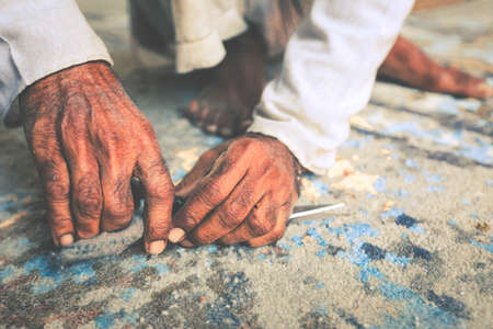Closeup of hand cutting carpet with scissors. Carpet cleaning service