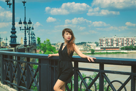 Beautiful Asian woman stands on Pont de Pierre bridge during her visiting Bordeaux, Franceの写真素材