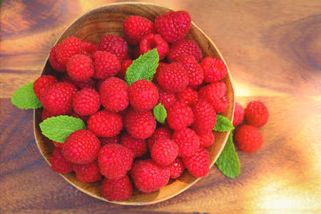 Ripe raspberries on wooden bowl. Healthy eating conceptの写真素材