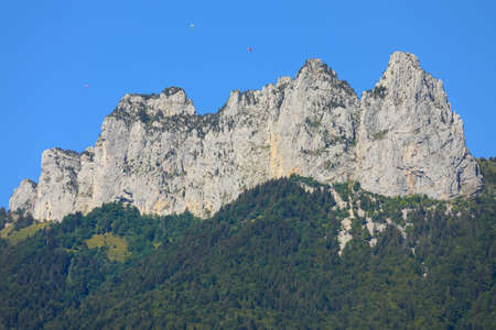 Top view of mountain peaks with blue sky and parachutes in  summerの写真素材