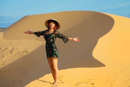 Beautiful asian woman enjoy her vacation on white sand dune in Mui ne, Vietnamの写真素材