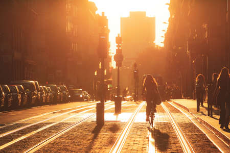 woman riding bicycle during the sunset in the city of Bordeaux in vintage styleの写真素材