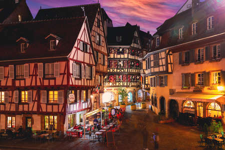 Colmar, Alsace, France April 2022 : Traditional half-timbered houses and restaurants on street in Colmar at twilight , Alsace rigion, Franceのeditorial素材