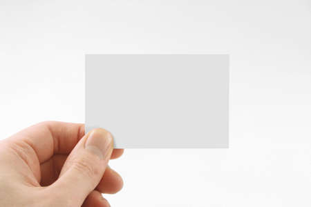 human hand holding a blank business card, isolated on white background