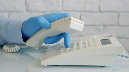 Man Wearing Protection Gloves in Hands Using Telephone Communication, Social Distancing Lifestyleの写真素材