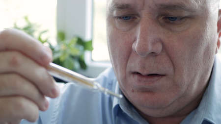 Man Having Coronavirus Symptoms Taking His Body Temperature in a Hospital Using a Thermometer with...