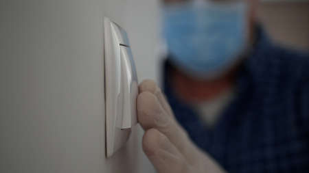 Man Wearing Medical Mask and Protection Gloves Enter in the Office Room Turning On the Light from...