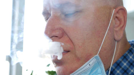 Image with a Man who Smokes a Cigarette Using on the Face a Protective Mask Against Virus Infection