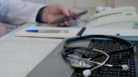 Image with a Doctor in Hospital Office Using Smartphone Communicationの写真素材