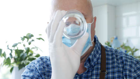 Image with a Bartender Wearing Protective Gloves and Face Mask Cleaning a Glassの写真素材
