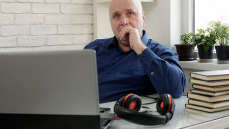 Image with a Person Using a Laptop and Headphones for an Online Video Conferenceの写真素材
