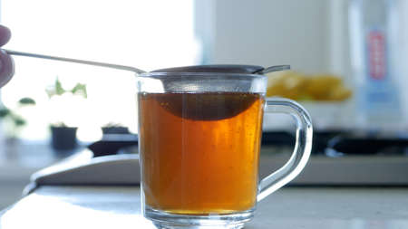 Image with Making a Hot and Aromatic Tea Using a Strainer and Natural Tea Leafsの写真素材