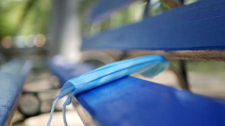 Used Medical Face Mask Abandoned on a Bench in the Park, Dangerous Garbageの写真素材