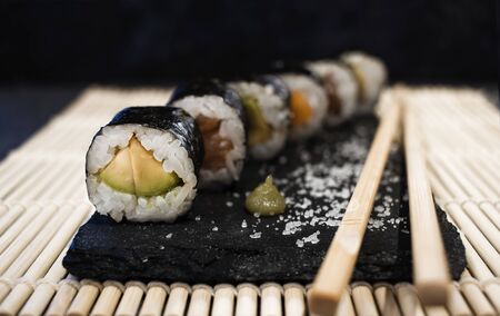 Sushi, on slate plate with wasaby sauce and chopsticks
