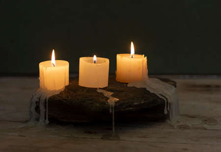 three burning candles in the darkの写真素材