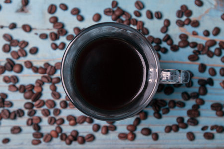 top view cup of coffee with scattered coffee beansの写真素材