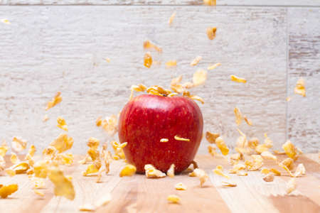 Cereal flakes falling on a red appleの写真素材