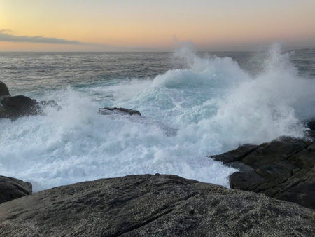 Beautiful sunset on the coastal edge of the beaches of Punta de Tralca beach, El Quisco, ValparaÃ­so, Chile. Waves hitting rocky shoresの写真素材