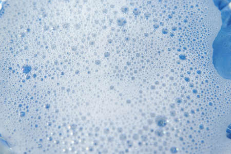 Suds and Soapy bubbles on blue waterの写真素材