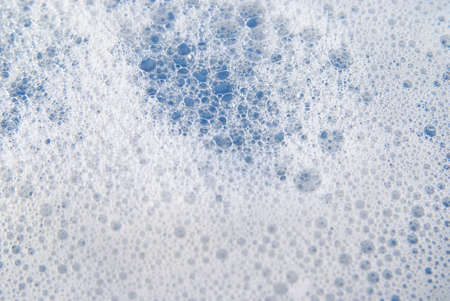 Suds and Soapy bubbles on blue waterの写真素材