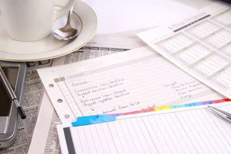 Office desk with woman's daily schedule and misc work materials
