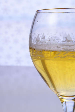 Golden wine in glass close up on pale backgroundの写真素材