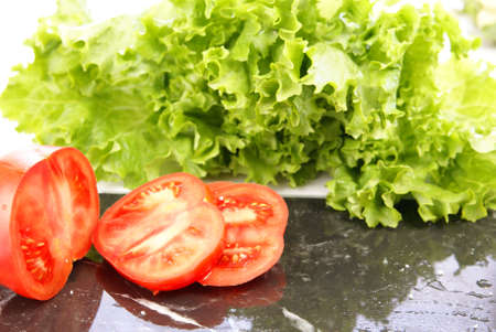 Fresh sliced ripe tomatoes on black marble cutting board.の写真素材