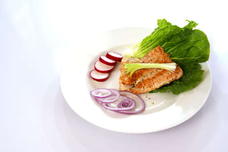 Cooked pink salmon with lettuce leaf, onions, and radish.の写真素材
