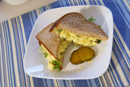 Egg Salad Sandwich on whole grain bread with pickles.の写真素材