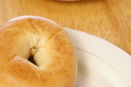 Plain bagel on white plate and wooden tableの写真素材