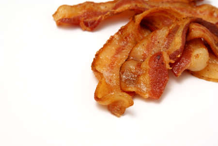 Sizzling Bacon. Fresh cooked bacon over white