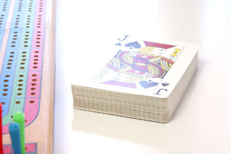 Retro Games. Wood cribbage game board with deck of cards next to it.