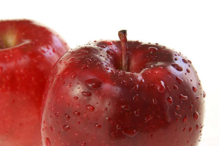 Close up of the top of a plump, ripe, juicy red apple on white backgroundの写真素材